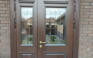 стальная двустворчатая дверь с ковкой между стеклом и отделкой МДФ